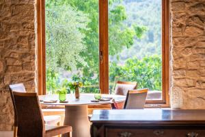 een eetkamer met tafels en stoelen en een groot raam bij La Torre del Visco - Relais & Châteaux in Fuentespalda