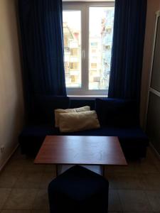 a blue couch in front of a window with a pillow at Sea House Guest House in Nesebar +22 photos
