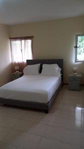um quarto com uma cama com lençóis brancos e uma janela em Recanto da Montanha em Rui Vaz