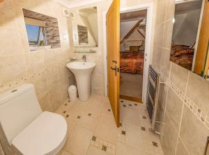 a bathroom with a toilet and a sink at Big Sky at Hive Beach in Burton Bradstock +44 photos