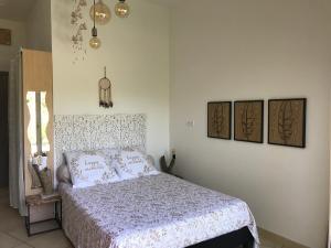 een slaapkamer met een bed met roze kussens erop bij LE CLOS DES VIGNES in Junas