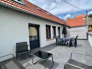 un patio con mesa y sillas y un edificio en Chez Arnaud et Thomas, en Dinsheim
