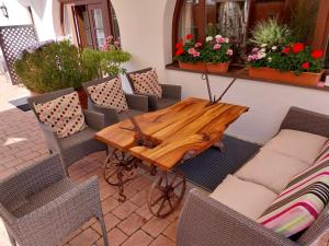 uma mesa de madeira e cadeiras num pátio em Jochum Hotel Garni em Fiss