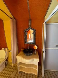 a bathroom with a sink and a mirror at Unique sahara camp in Merzouga