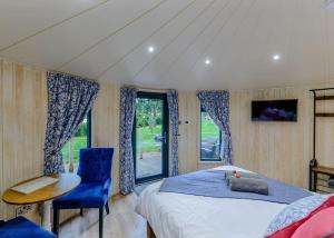 a bedroom with a bed and a chair and a window at Mallory Meadows in Kirkby Mallory