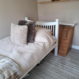 a bedroom with a white bed and a dresser at Oakworth in Oakworth