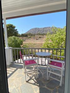 a patio with a table and chairs on a balcony at Euphoria Estate 2 in Agia Marina Aegina