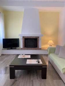 a living room with a couch and a fireplace at Euphoria Estate 2 in Agia Marina Aegina