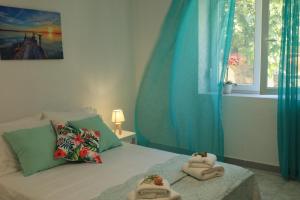 1 dormitorio con 2 toallas en una cama con ventana en Η Ροδιά - Rodia en Agios Nikolaos