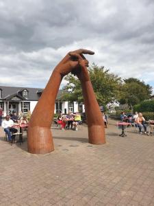 a statue of two hands in a park at large comfortable 1st floor apartment with private yard in Longtown