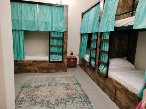 a bedroom with two bunk beds and a rug at The Villa Hostel Abu Dhabi in Abu Dhabi