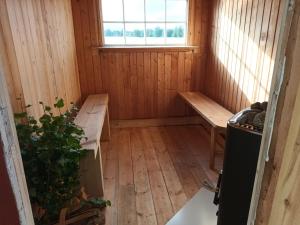 Cette petite chambre dispose d'un banc et d'une fenêtre. dans l'établissement Charmig gård med bastu, strandtomt och utedusch i naturskönt område, à Sveg
