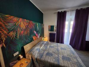 een slaapkamer met een bed met een schilderij aan de muur bij Casetta Lungomare in Pescara