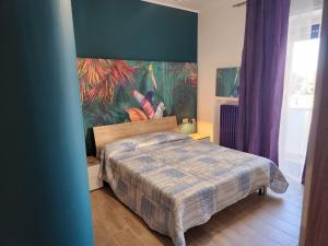 sypialnia z łóżkiem i obrazem na ścianie w obiekcie Casetta Lungomare w mieście Pescara