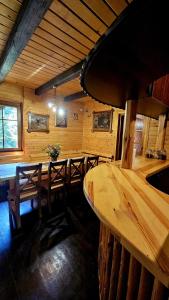 a dining room with a table and benches in a cabin at Leśna Osada Szegdy 