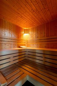 a large wooden sauna with a bench in it at Apartament Tower Premium - siłownia, sauna, ścisłe centrum - by Kairos Apartments in Katowice