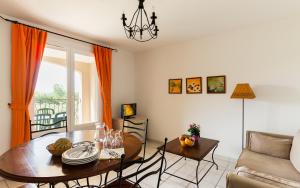 a living room with a table and a couch at Lagrange Vacances Le Domaine de Bourgeac in Paradou