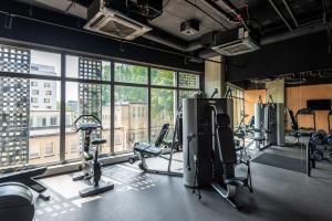 a gym with cardio equipment and a large window at Apartament Tower Premium - siłownia, sauna, ścisłe centrum - by Kairos Apartments in Katowice