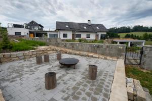 eine Terrasse mit einem Tisch, einem Zaun und einem Haus in der Unterkunft Ubytování v soukromí v Šachu in Volfířov