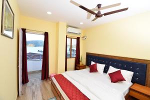 una camera da letto con un letto con cuscini rossi e una finestra di The Hook BnB, Port Blair a Haddo
