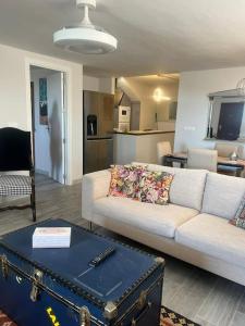 een woonkamer met een witte bank en een tafel bij Palm Beach Apartment in La Duquesa in Manilva