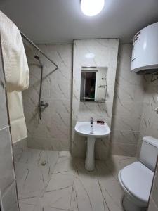 a bathroom with a sink and a shower and a toilet at Гостевой дом Razamlux in Bosteri