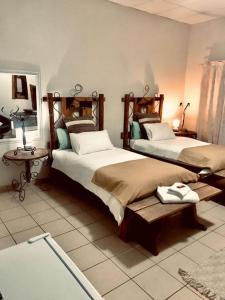 sypialnia z 2 łóżkami i stołem w obiekcie Leather and Lace & a Suitcase w mieście Groutfontein