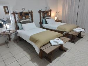 Un dormitorio con 2 camas y una mesa con lámparas. en Leather and Lace & a Suitcase, en Groutfontein