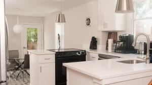 a kitchen with white cabinets and a black stove at King Bed~Serene Old Town Sanctuary in Alexandria