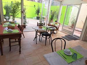 a dining room with tables and chairs and a patio at Hôtel Beauséjour in Nevers