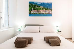 a bedroom with a large white bed with two lamps at Olimpia Via Vitani - The House Of Travelers in Como