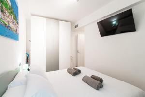 a white bedroom with two towels on a bed at Olimpia Via Vitani - The House Of Travelers in Como