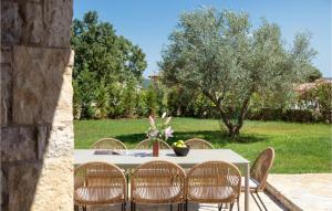 une table avec des chaises et une table avec un arbre dans l'établissement Villa Megi, à Sveti Lovreč Pazenatički