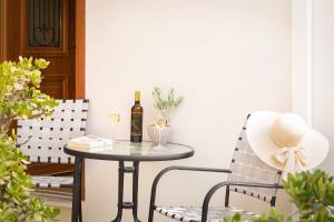 a table with a bottle of wine and two chairs at Blue studio in kantouni in Kokkari