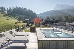 a deck with a chair and a swimming pool at Paramount Alma Suites in Sesto