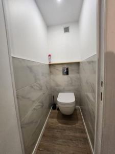 a bathroom with a white toilet in a room at Charment studio proche Paris 15 in Malakoff