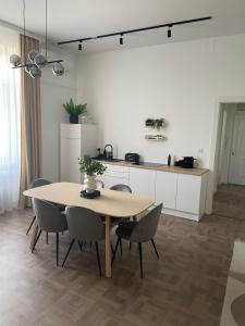 y cocina con mesa de comedor y sillas. en Modern új lakás a belvárosban en Debrecen