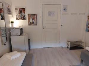 a small white room with a refrigerator and a door at Vinstra Hostel in Vinstra