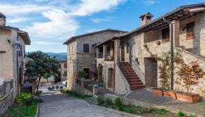 una strada in un centro storico con edifici in pietra di Alloggio Flaminia con parcheggio di proprietà! a Bevagna