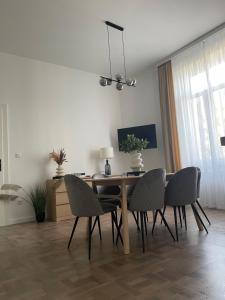 uma mesa de jantar com quatro cadeiras e uma mesa e uma sala de jantar em Modern új lakás a belvárosban em Debrecen