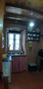 阿加尼爾的住宿－Casa do Loureiro，厨房设有水槽和窗户。