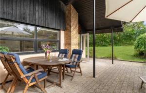 a patio with a table and chairs and an umbrella at Nice Home In Vejby With Kitchen in Vejby
