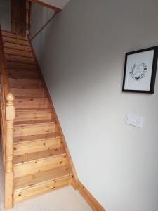 a wooden staircase with a white wall at Home in Ennis in Ennis