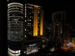 Blick auf ein hohes Gebäude in der Nacht in der Unterkunft Marriott Absheron 2 bedroom apartment in Baku