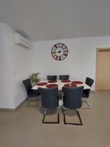 a meeting room with a table and chairs and a clock at Apartments Bora in Ližnjan