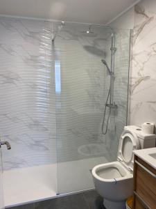 a bathroom with a toilet and a glass shower at Del Mar three bed flat. in Puerto de Sagunto