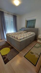 a bedroom with a bed and two rugs on the floor at Apartments Bora in Ližnjan