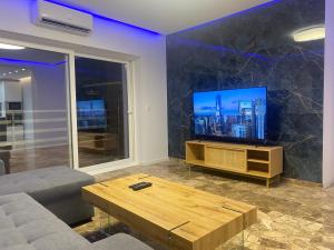 uma sala de estar com uma televisão e uma mesa de centro em Del Mar three bed flat. em Puerto de Sagunto