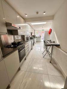 a kitchen with white cabinets and a table in it at Double and single rooms in Bromley by bow in London