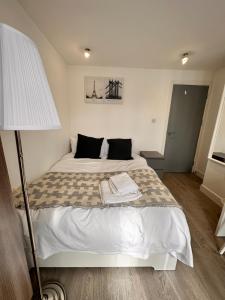 a bed in a room with a lamp and a bed sidx sidx sidx at Double and single rooms in Bromley by bow in London